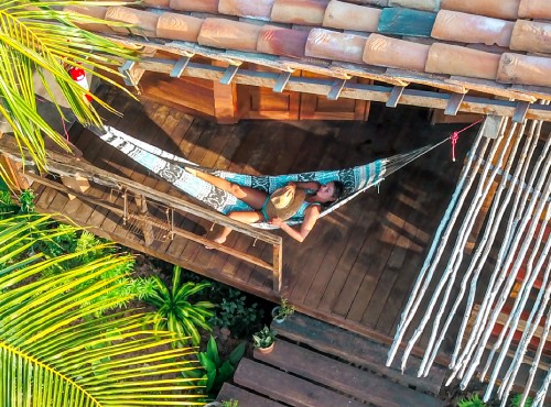 A lady relaxing on a hammock in the chalets at Convento Arcadia, Atins
