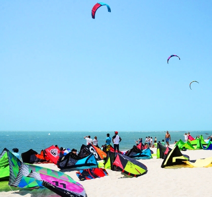 A group of people on the beach getting ready to kitesurf