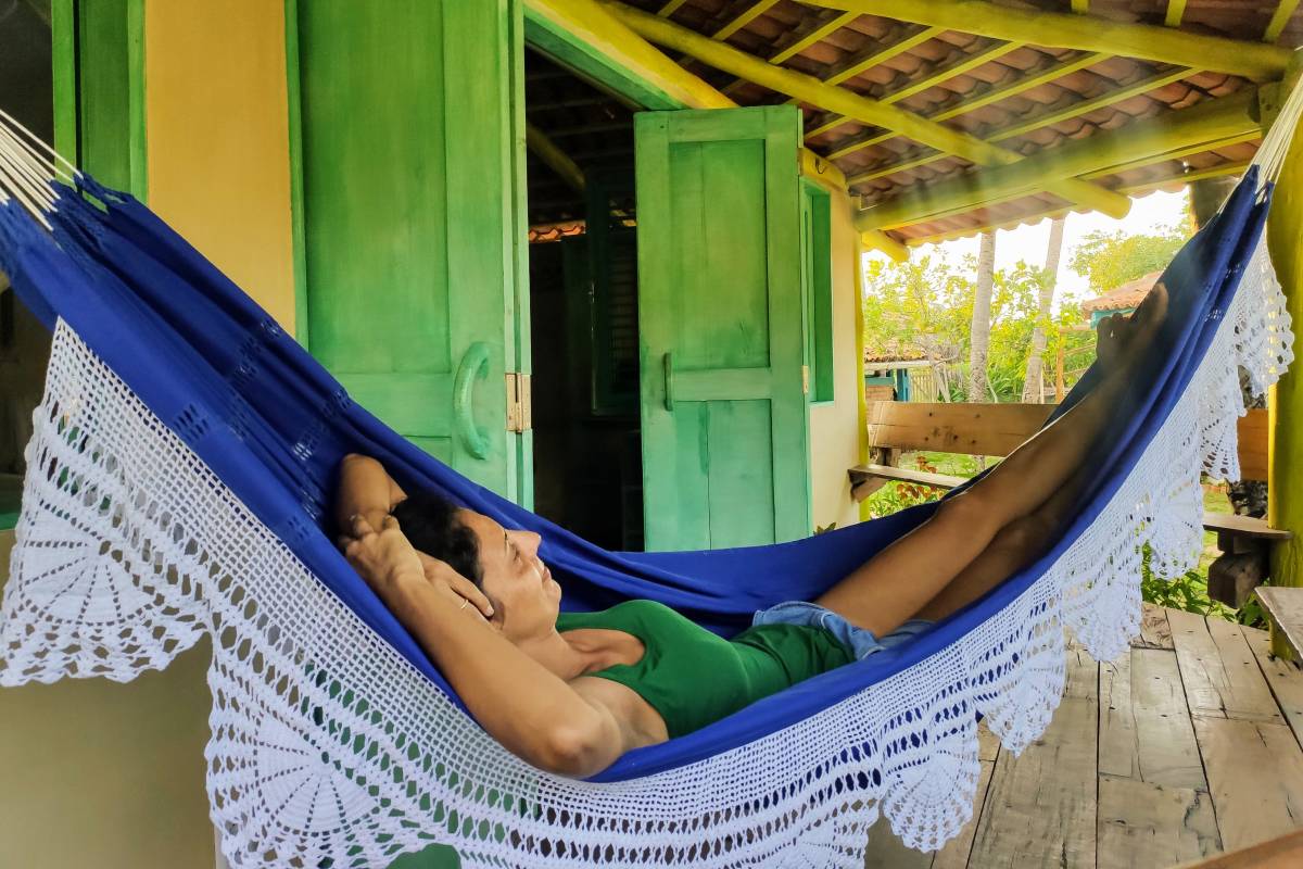 A man relaxing on the hammock of the Standard Chalet Triple at Convento Arcadia, Atins