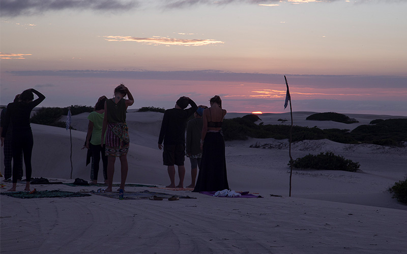 A group of people doing Yoga on the Sand dunes