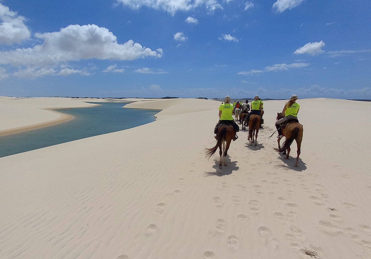 A group of people horseback riding in Lençóis Maranhenses
