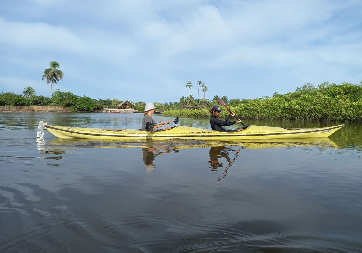 Two people Kayaking across a river