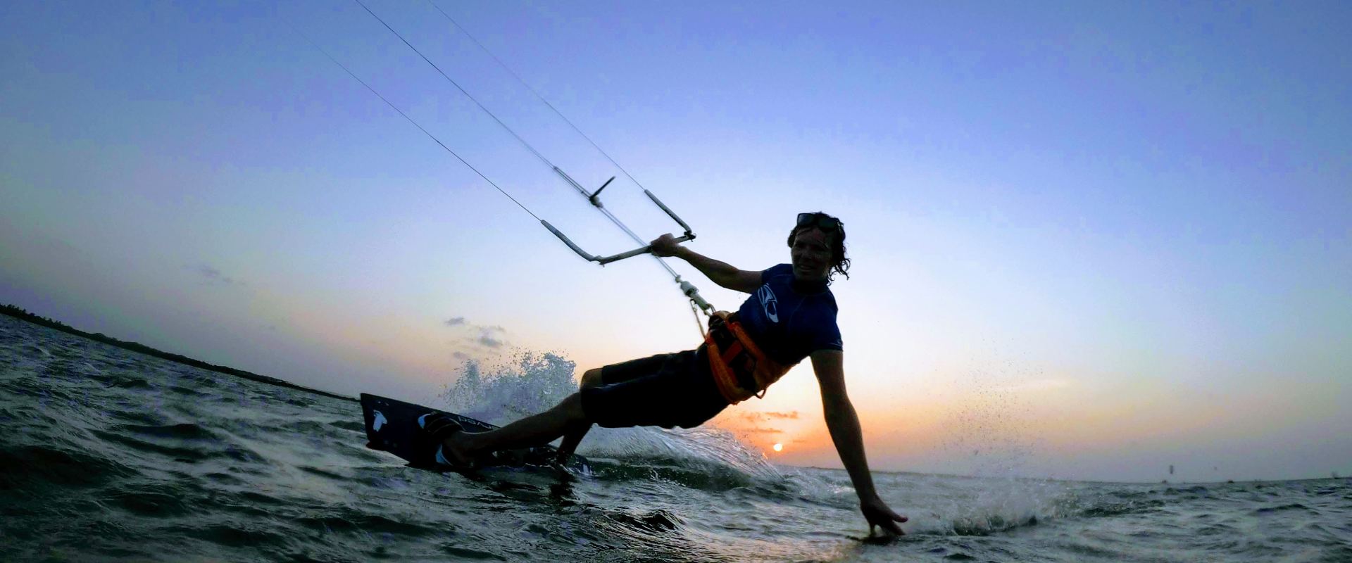 a person kitesurfing in the evening