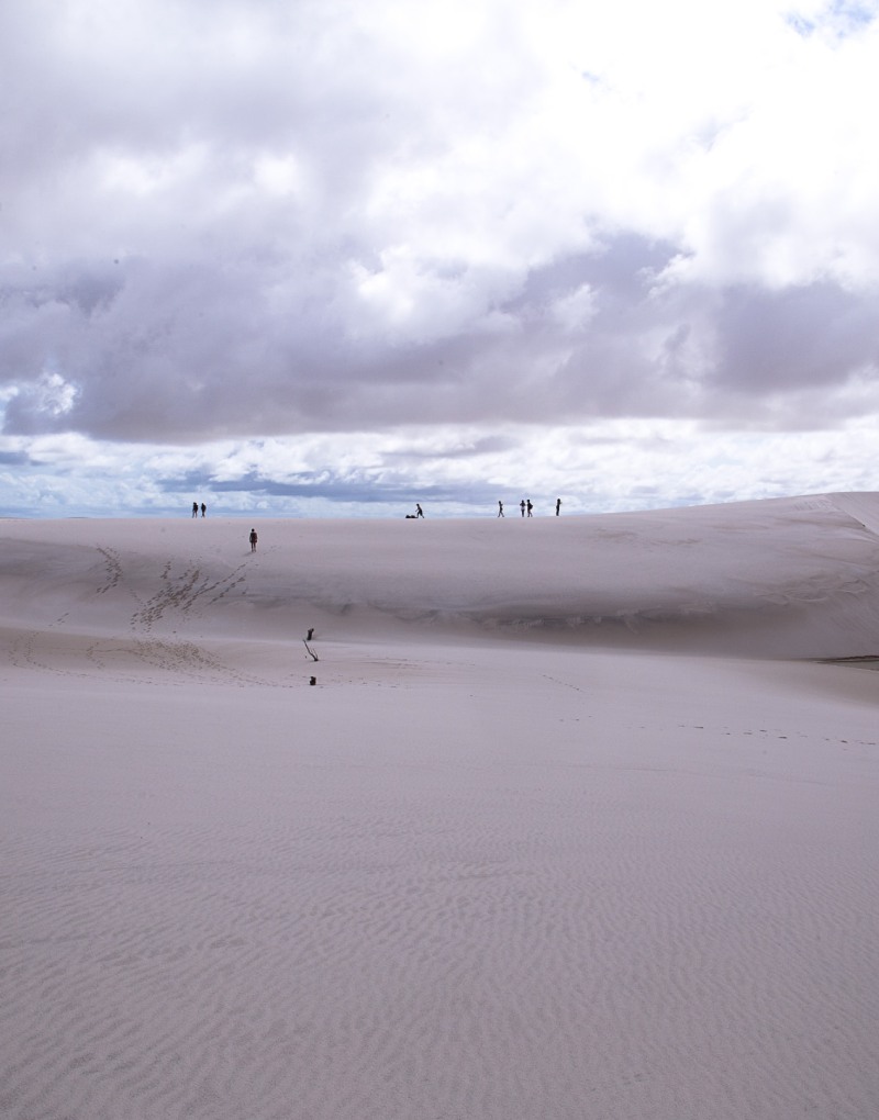 People trekking though the sand dunes in Atins